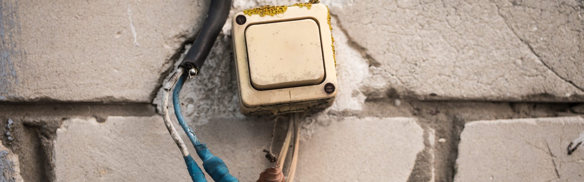 The old switch on the brick wall, twisted the blue tape.